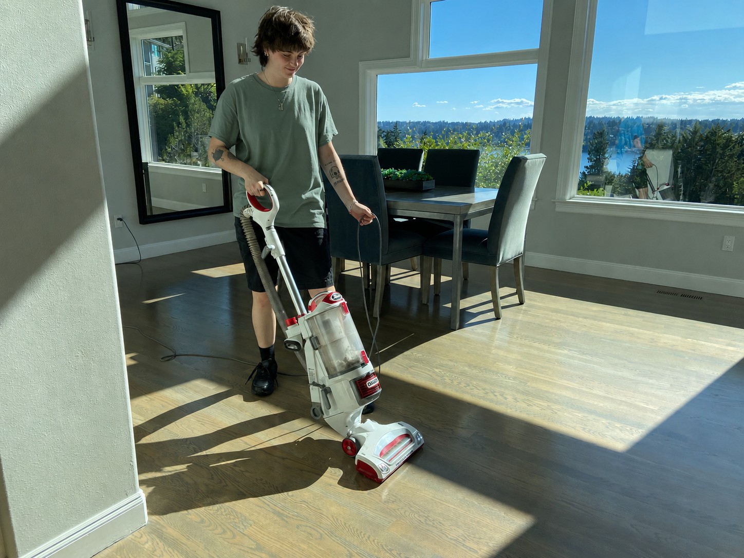 A MaidWise cleaner vacuuming a bright living room